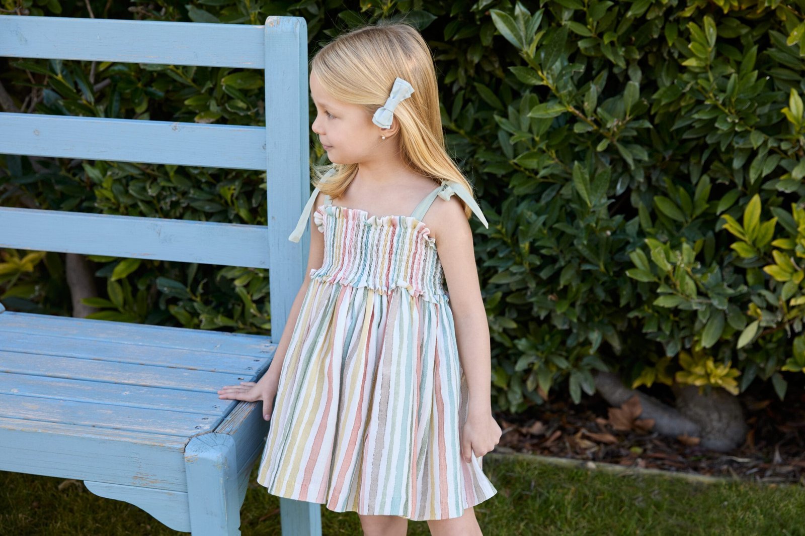 Niña con vestido de rayas pastel de Martín Aranda – moda infantil elegante para primavera verano